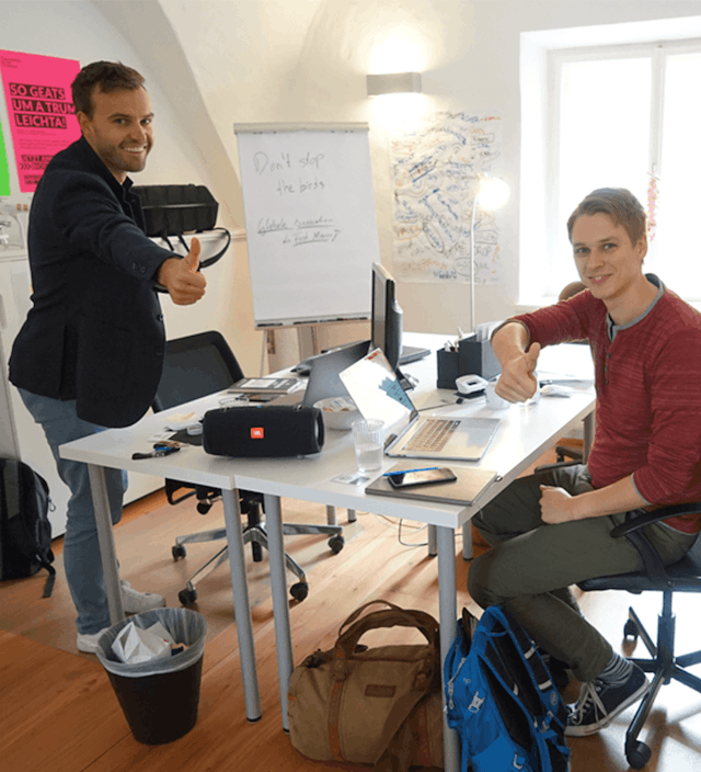 the two founders giving thumbs up in an office environment
